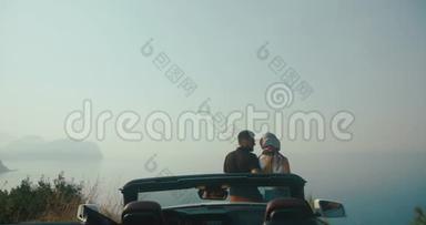 浪漫的公路旅行。 时尚的男人和女人站在黑山某处的汽车前欣赏美丽的风景